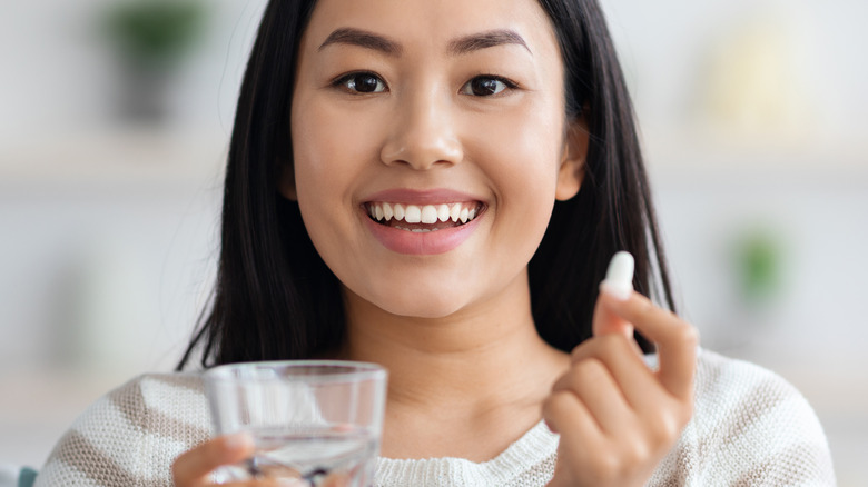 smiling woman taking multivitamin