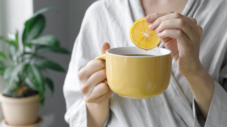 dipping lemon slice in coffee