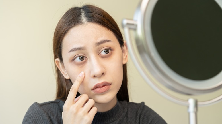 Woman looking at her dark circles