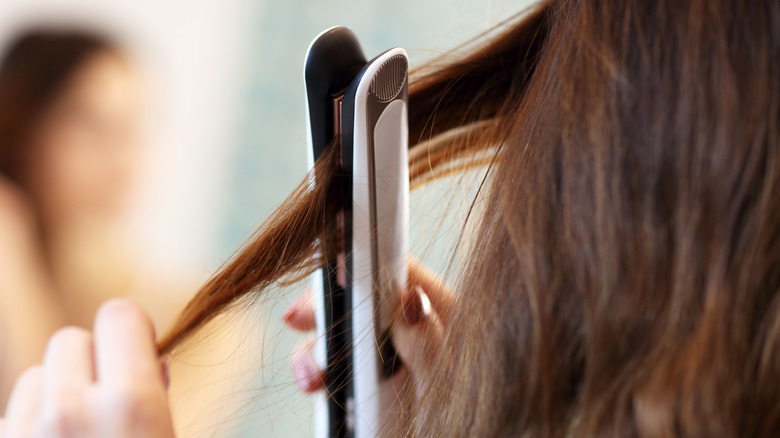 woman straightening brown hair 