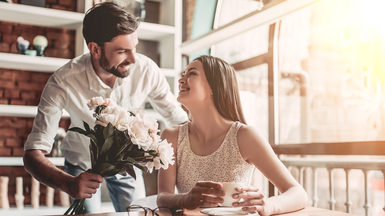 Man surprising partner with flowers