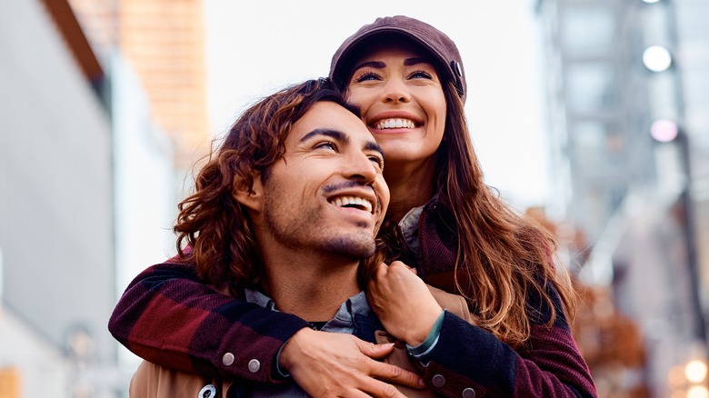 Smiling couple having piggyback ride