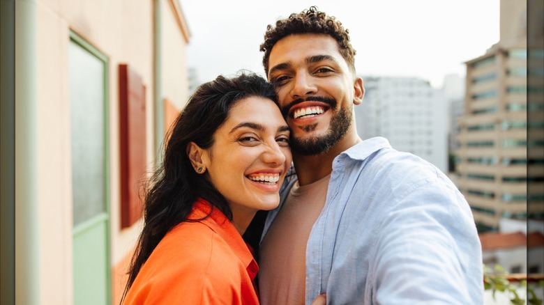 A couple poses for a selfie smiling together.