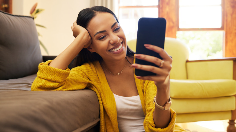 woman smiling at smartphone