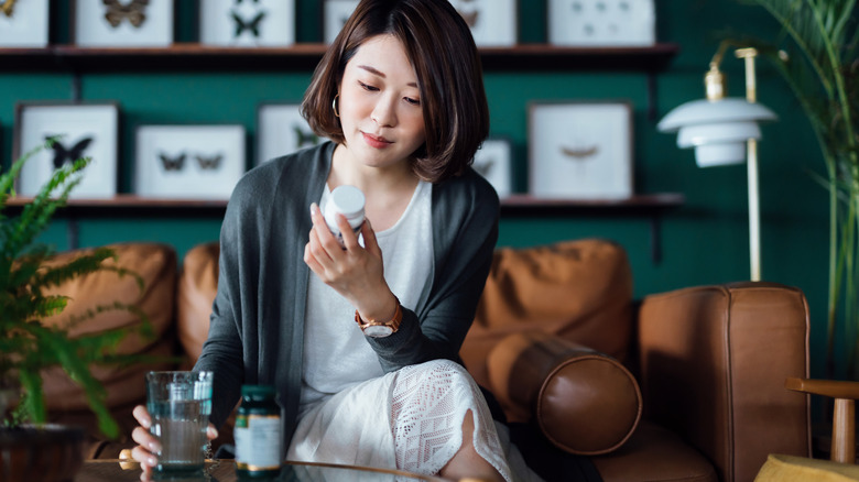 woman holding medicine and water