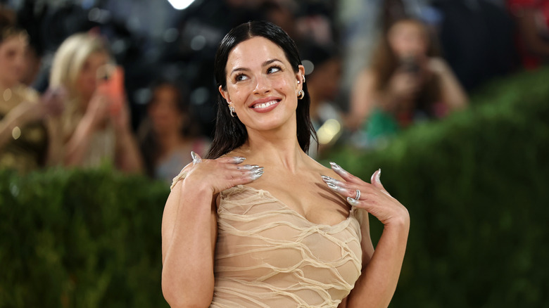 Ashley Graham smiles in a biege dress