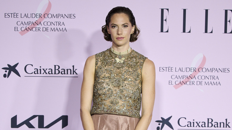 Emma Ferrer wears a slicked back hairstyle and two-toned dress at an event.