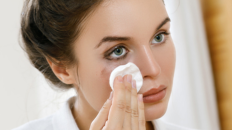 woman removing eye makeup 