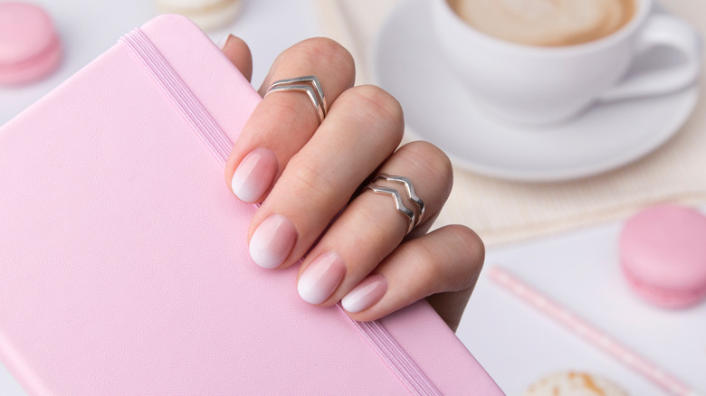 baby boomer nails holding a notebook