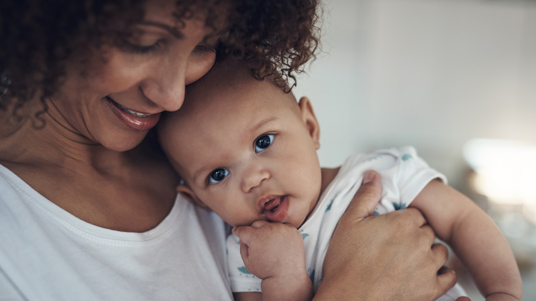 A woman cuddling a baby