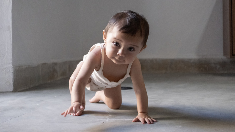 A baby in a diaper crawling towards the camera