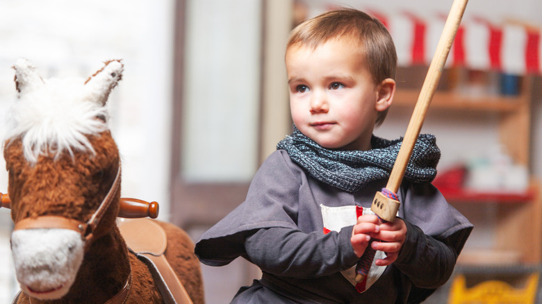 A toddler playing with a toy sword