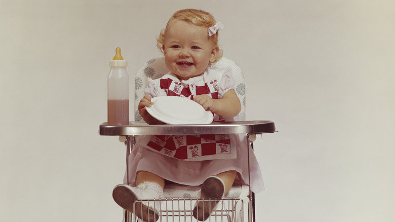 Baby girl sitting in an old-fashioned high chair