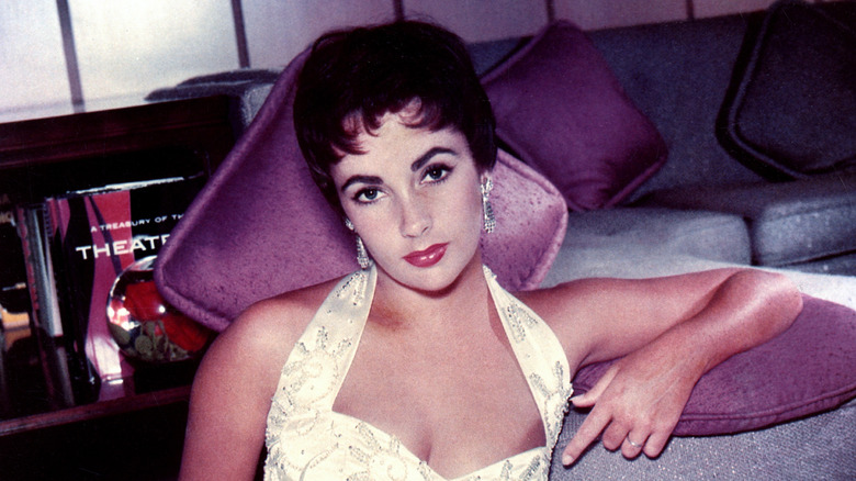 Elizabeth Taylor posing in a yellow dress with a pixie cut