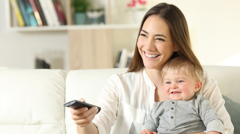 A mother and baby watching TV together