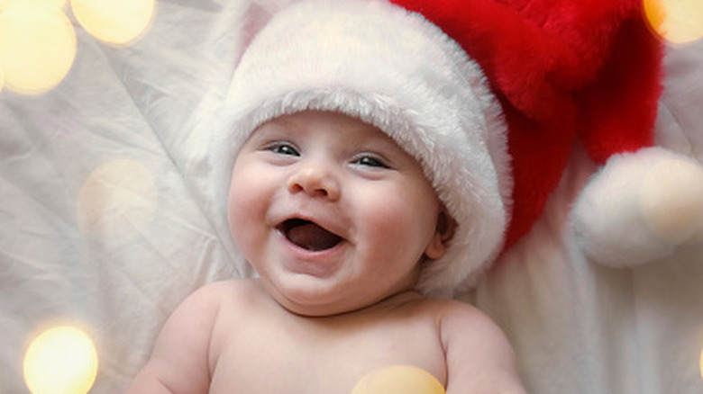 A smiling baby with a Santa hat