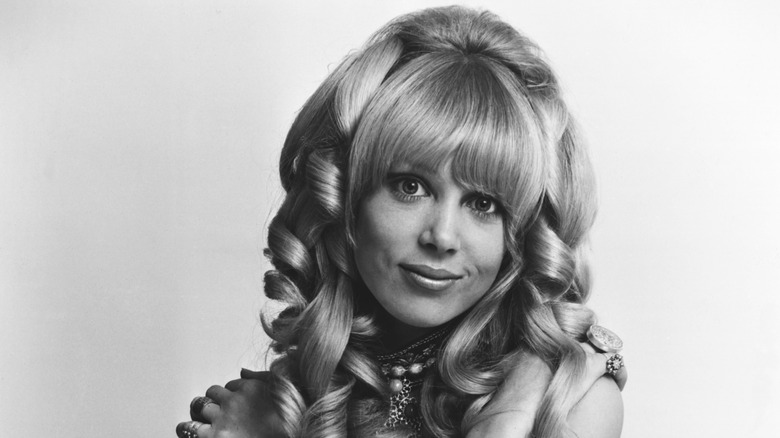 Pattie Boyd modeling a wig in 1966 in a black and white photo