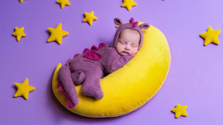 Little girl in a dragon onesie sleeping
