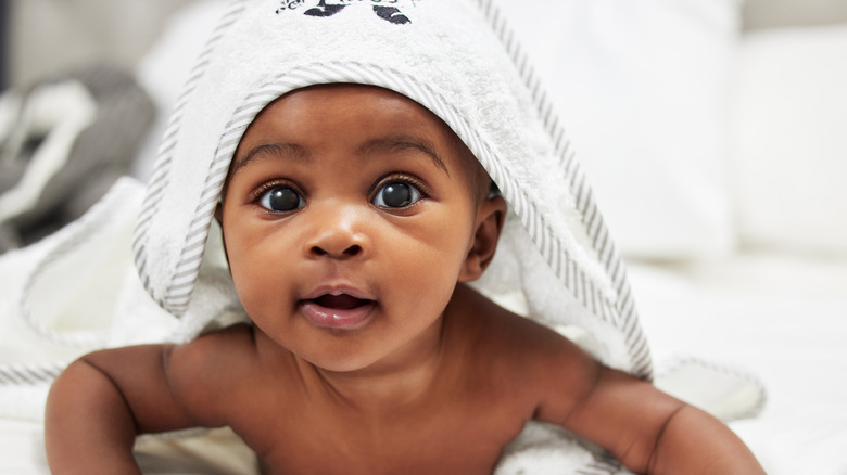 A baby with a towel on its head