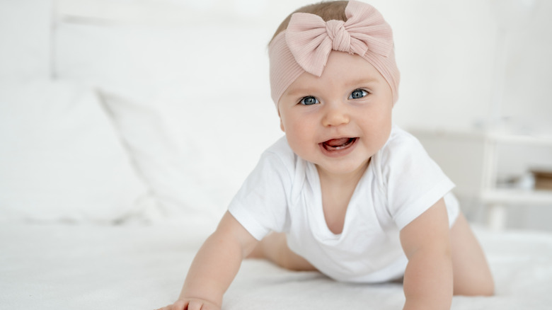 A baby with a pink bow around her head