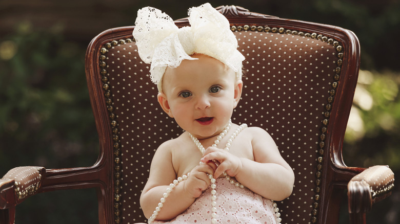 A smiling baby girl with a big white hairbow