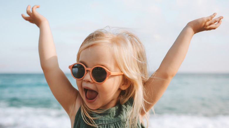 A little girl cheering at the beach