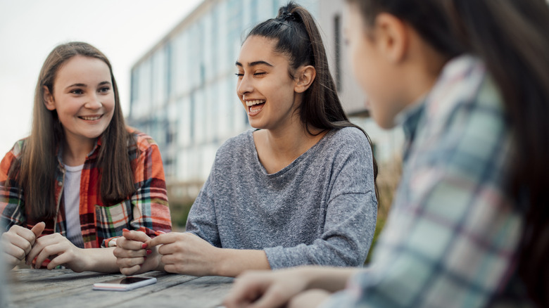 Girls chatting, laughing around table