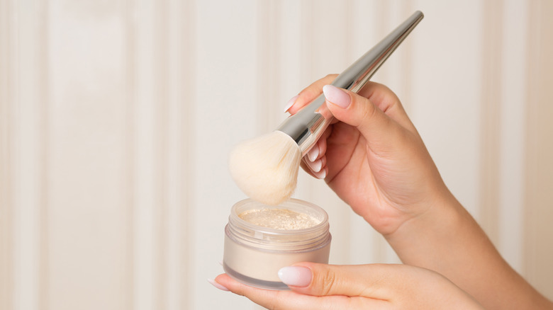 woman holding brush and powder