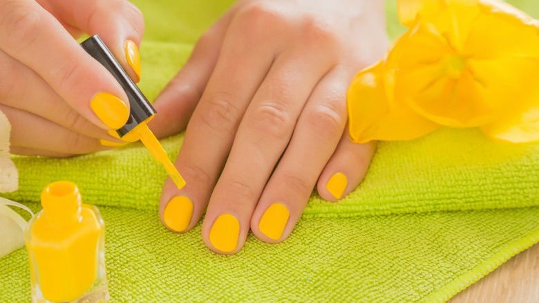Yellow manicure with polish bottle