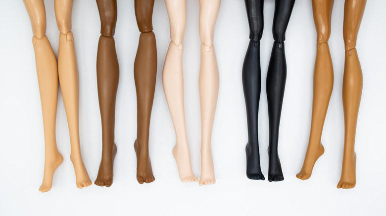 Several sets of toy Barbie doll legs in various skin tones