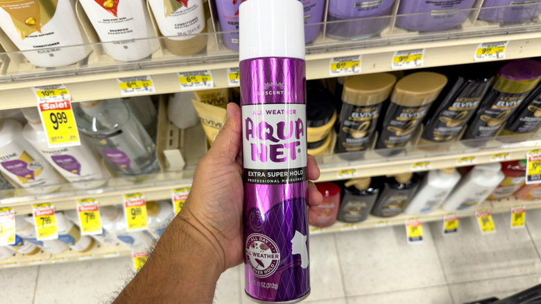 A person holding a can of '80s Aqua Net hairspray