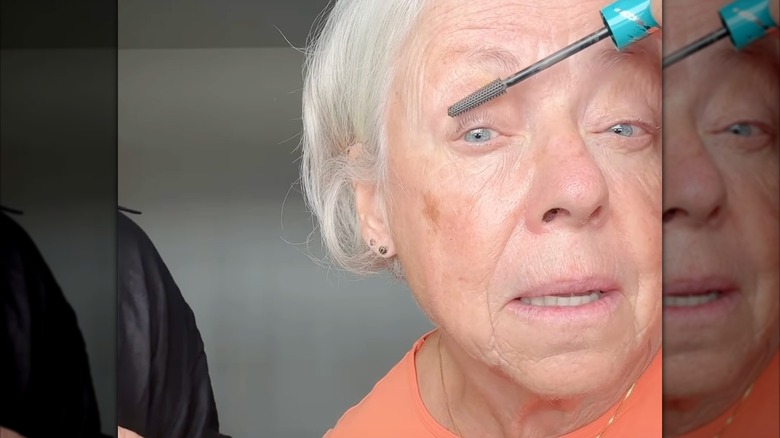 A woman applying gray mascara