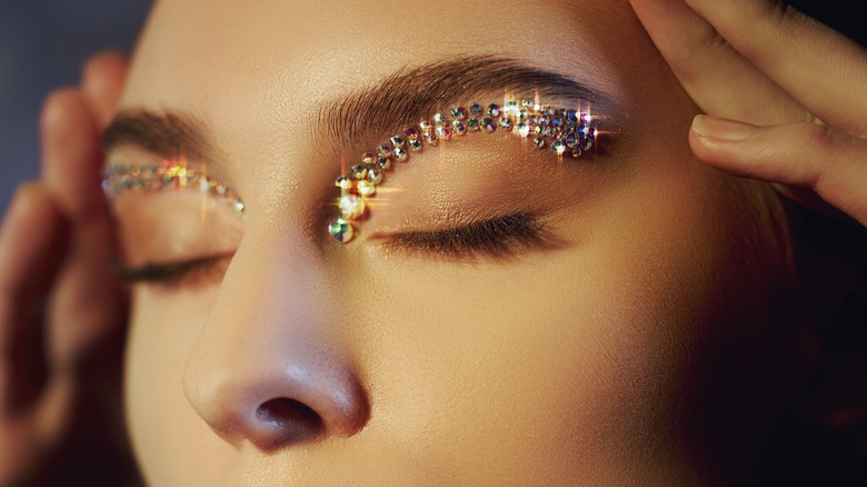 Woman with rhinestones on eyelid