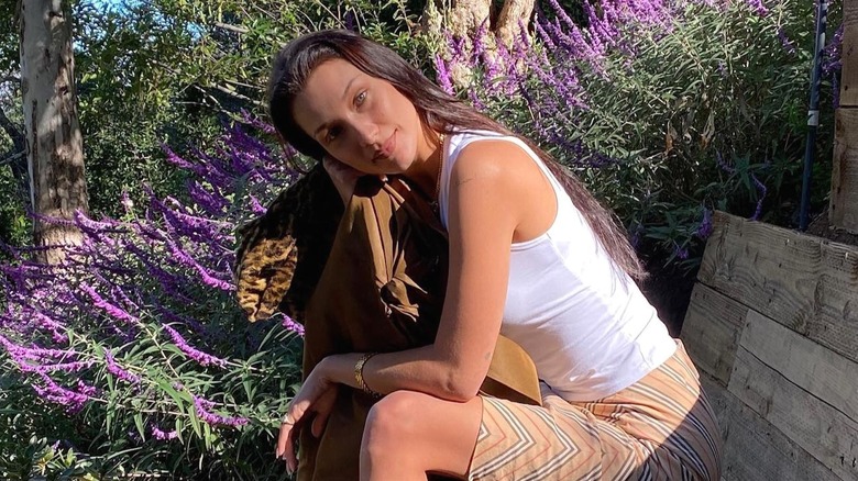 Bella Hadid posing by flowers