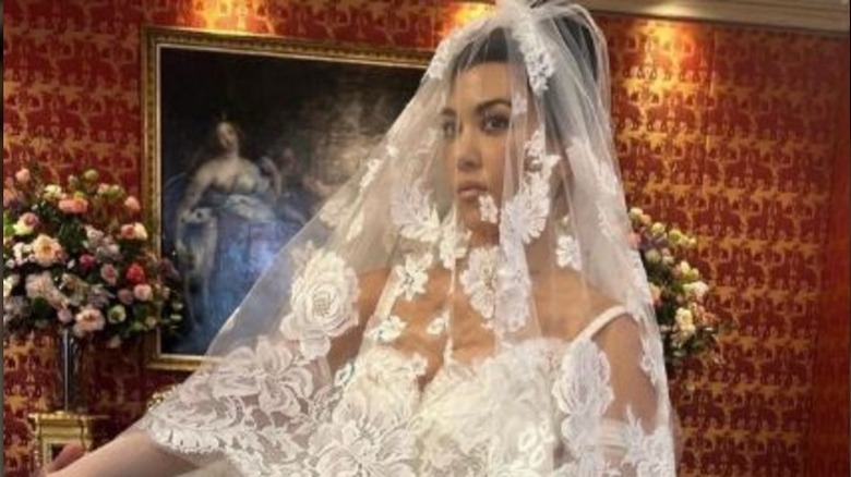 Kourtney Kardashian poses in a floral lace wedding veil