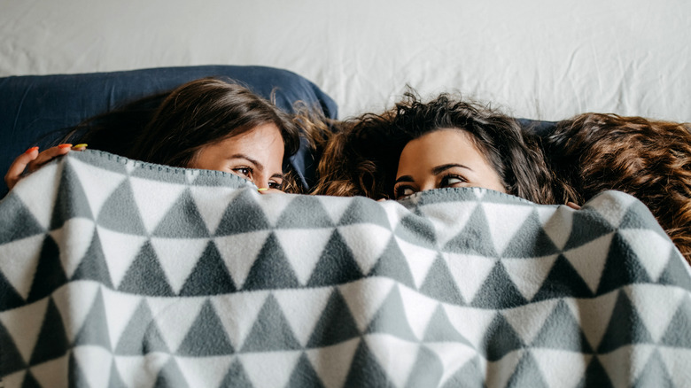 Two women sharing a blanket
