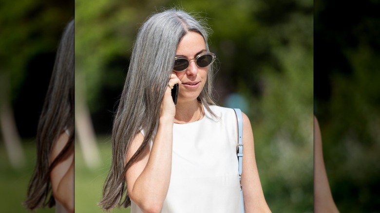 A woman with gray hair that has dark lowlights