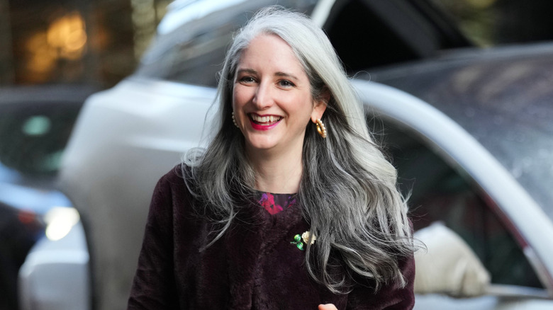 A woman with gray hair that has dark lowlights
