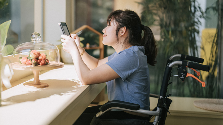 Woman in wheelchair using e-reader