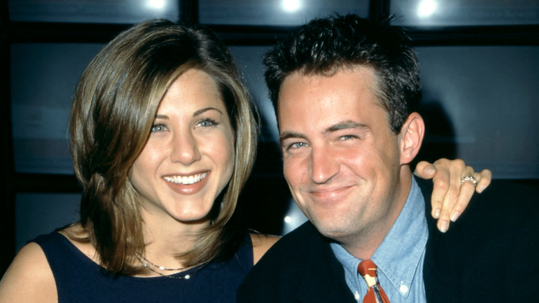 Jennifer Aniston with "The Rachel" haircut posing beside Matthew Perry