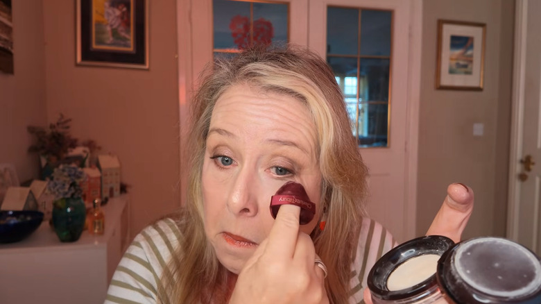 Woman applying powder with a sponge
