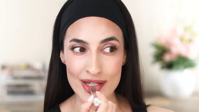 Woman applying Dior lipgloss