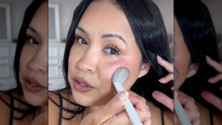 Woman applying Nars liquid blush with a brush