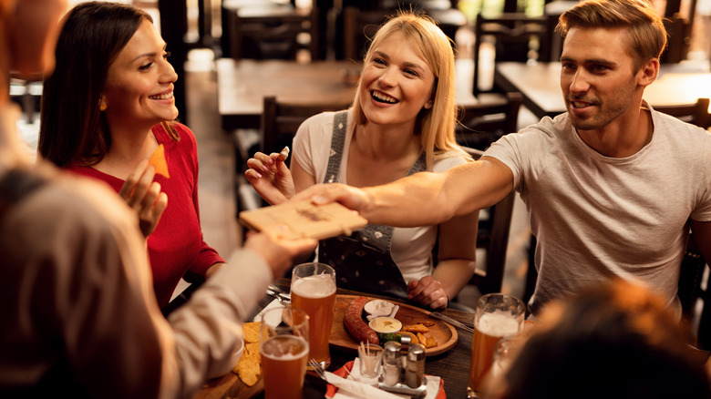 Friends paying bill restaurant 