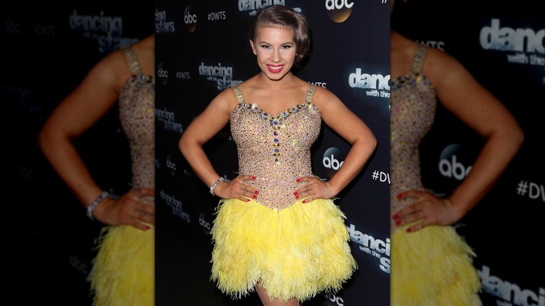 Bindi Irwin in a rhinestoned bodice with a fur yellow skirt attached.