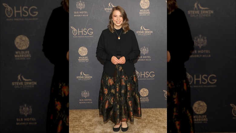 Bindi Irwin in a black mock-neck sweater with the front tucked into an A-line floral maxi skirt at the 2023 Steve Irwin Gala