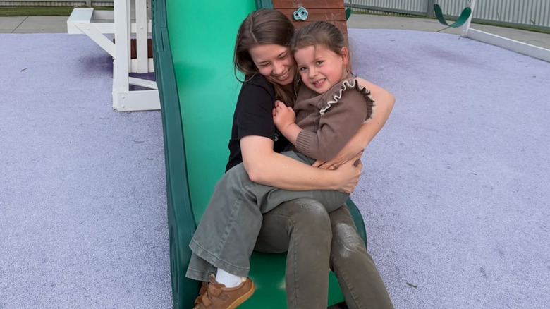 Bindi Irwin posing for a photo on a slide with her daughter Grace Warrior