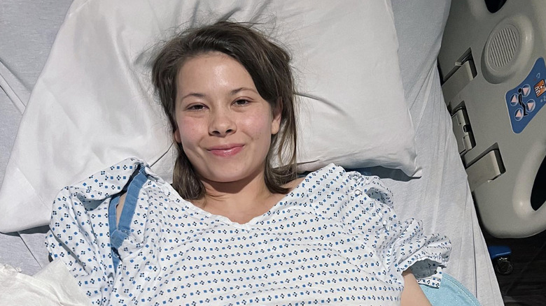 Bindi Irwin in a hospital bed and gown following her endometriosis surgery