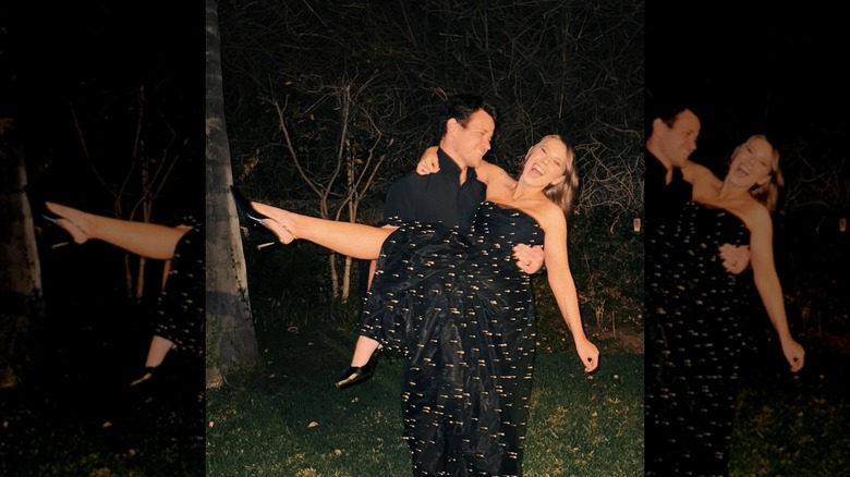 Chandler Powell holding Bindi Irwin who's wearing a strapless dress