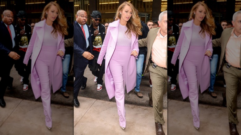 Blake Lively walking in a pink 'fit consisting of high-waisted pants, a netted top, and a matching coat